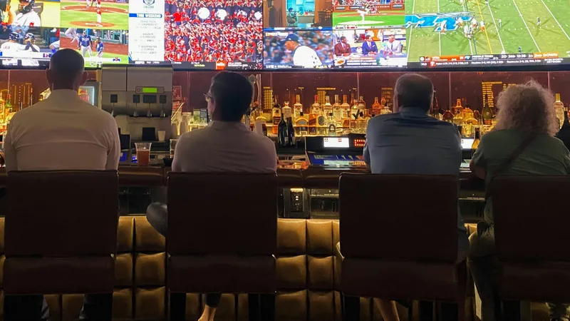a group of people sitting at a bar watching TV by @amit_lahav